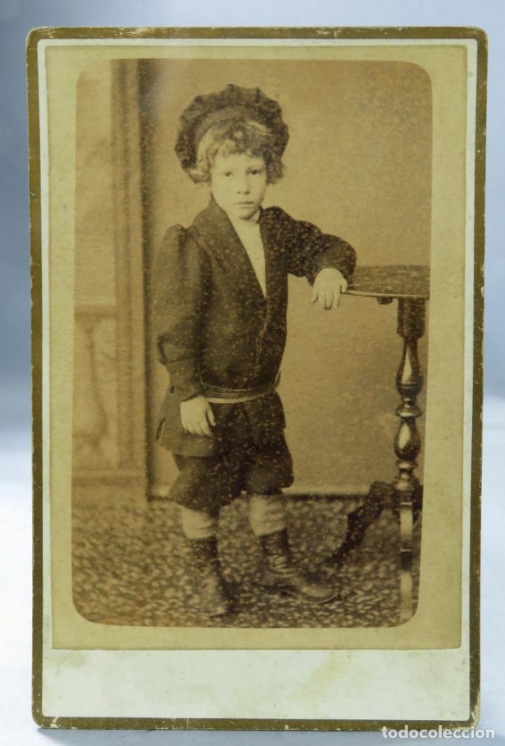 Fotografia antica: Fotograf&iacute;a alb&uacute;mina ni&ntilde;o posando traje y gorro posando velador H Dieguez hacia 1890 S XIX