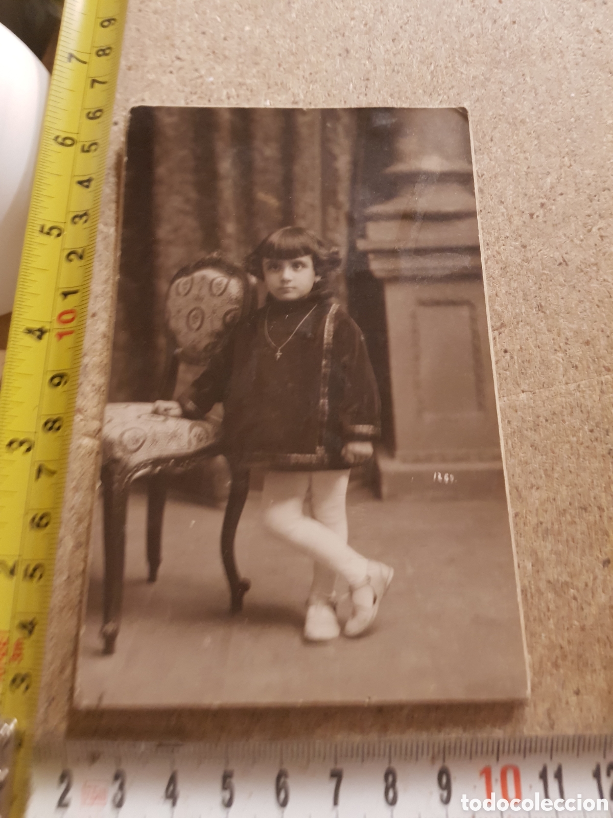 Fotograf&iacute;a antigua: Antigua fotograf&iacute;a de los a&ntilde;os 20 de una ni&ntilde;a abollada en una silla.