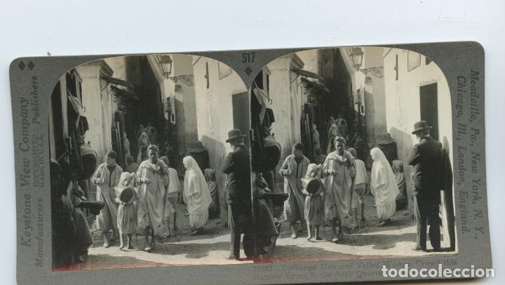 Photographie ancienne: Hombres con turbante y mujeres con velo en una calle del barrio &aacute;rabe de Algiers, Argelia.  Keystone