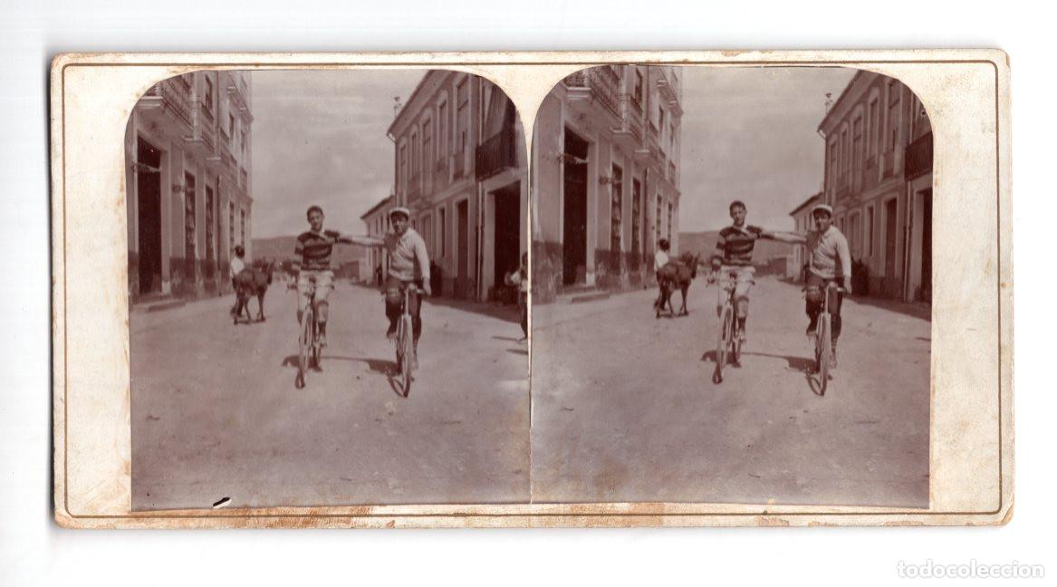 Fotograf&iacute;a antigua: ESTEREOSC&Oacute;PICA ANTIGUA QUE MUESTRA A DOS HOMBRES POSANDO CON BICICLETAS EN UNA CALLE RESIDENCIAL.