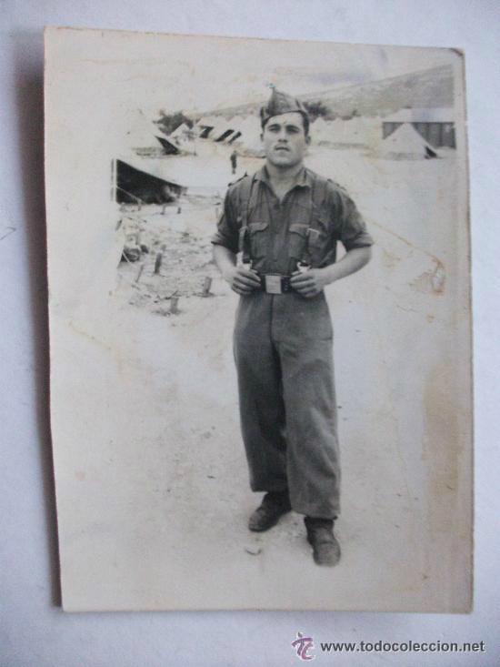 Fotografia antiga: MILITAR : SOLDADO CON MONO Y CORREAJE Y TIENDAS DE CAMPA&Ntilde;A AL FONDO . A&Ntilde;OS 40 ... 6,5 x 9 cm