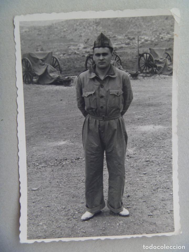 Fotografia antiga: FOTO DE MILITAR CON MONO, GORRILLO Y ALPARGATAS , DETRAS PIEZAS DE ARTILLERIA TAPADAS