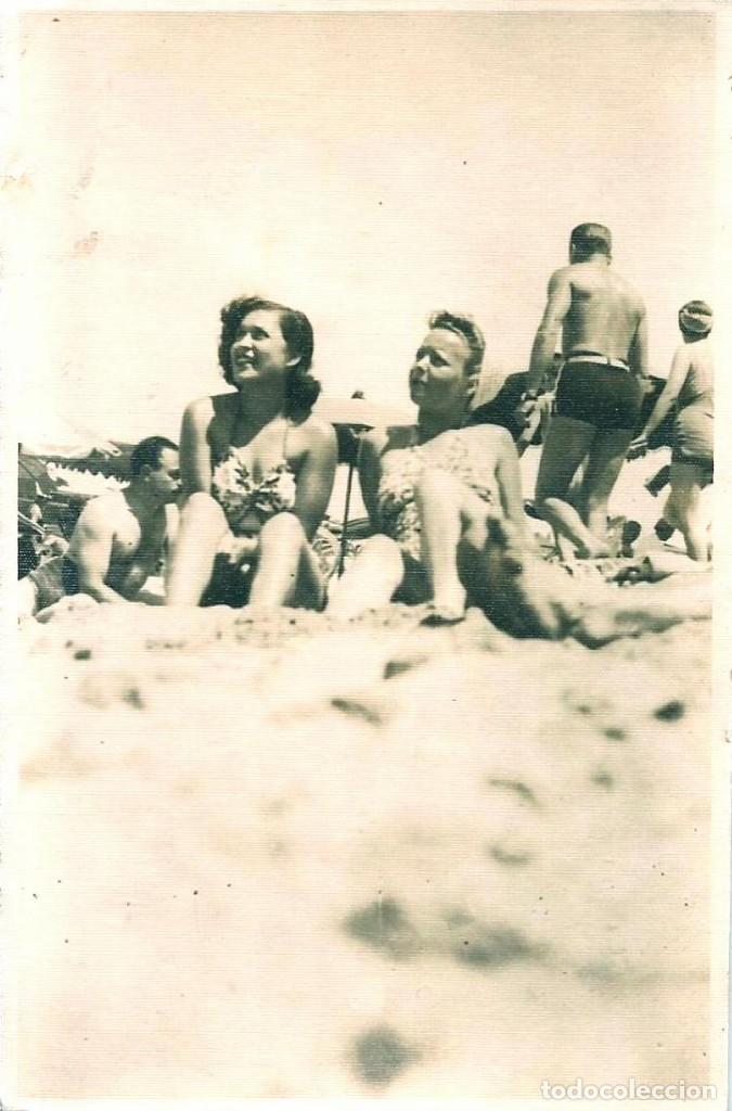 Fotograf&iacute;a antigua: X1516 Jovenes se&ntilde;oritas en ba&ntilde;ador sentadas juntas en la playa y hombre de espaldas Foto Postal 1940