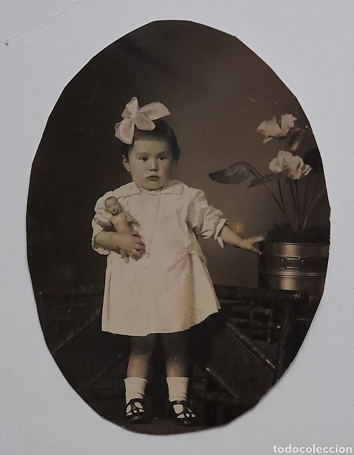 Fotografia antiga: Foto ovalada de ni&ntilde;a con mu&ntilde;eco en estudio fotogr&aacute;fico. A&ntilde;os 39s.