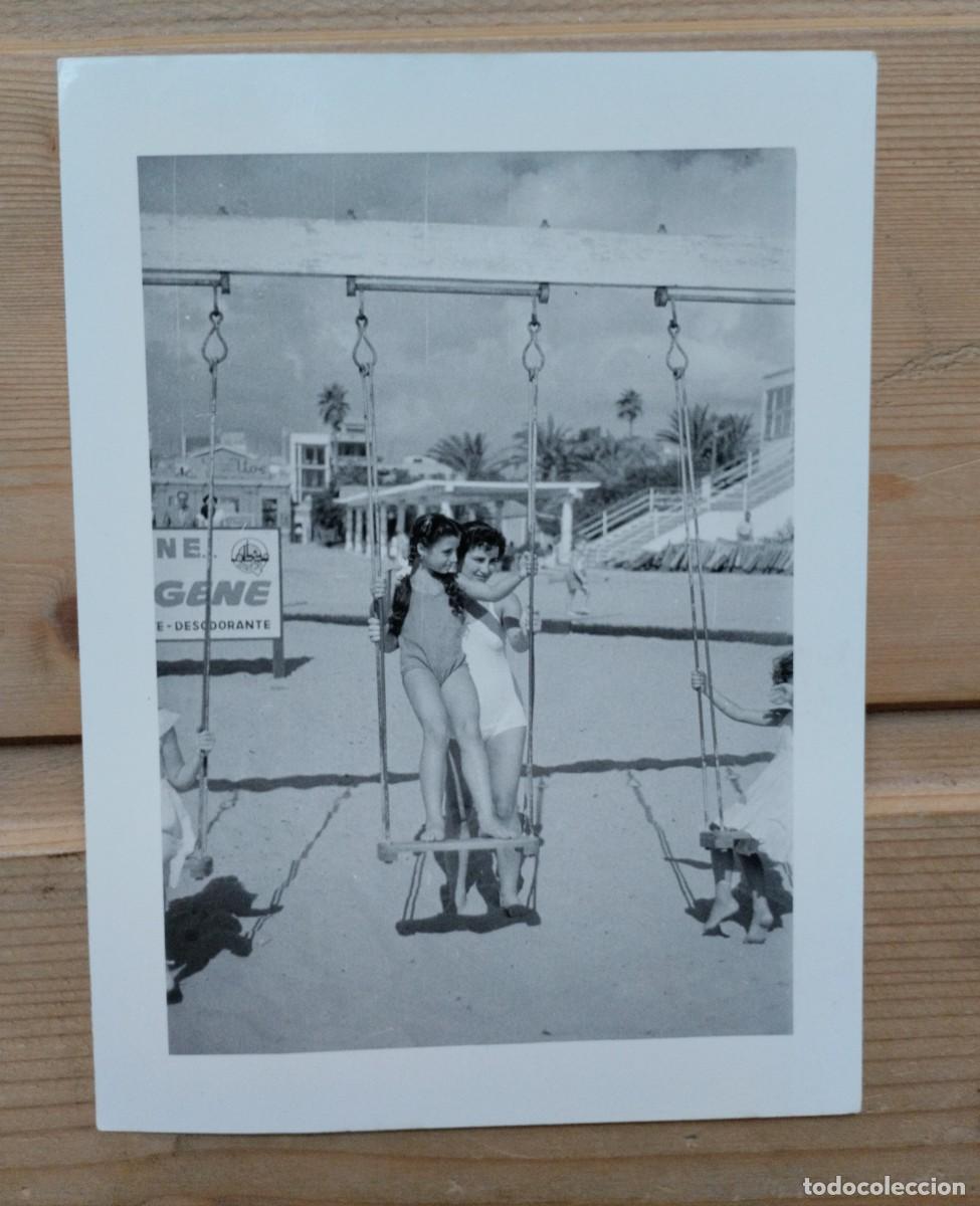 Fotografia antiga: Fotograf&iacute;a antigua de una mujer y una ni&ntilde;a en ba&ntilde;ador en los columpios de una playa