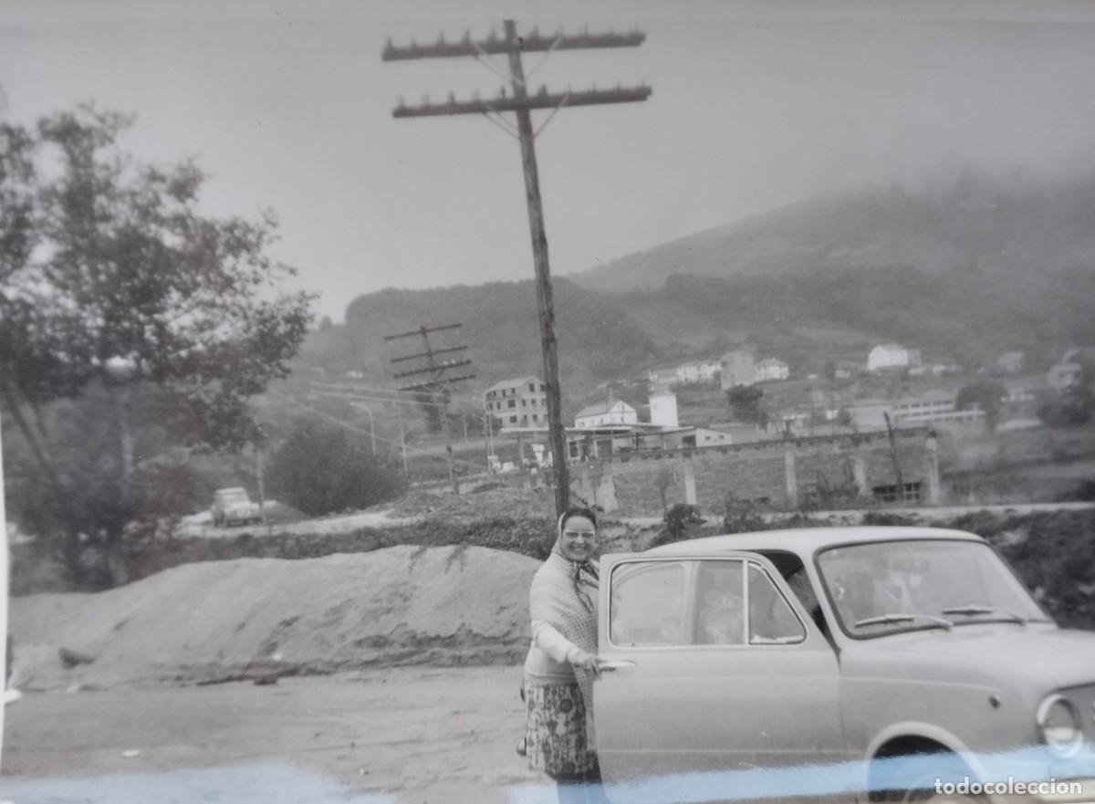 Fotograf&iacute;a antigua: Fotograf&iacute;a antigua de una mujer posando junto a un coche Seat 850. Postes de luz de madera