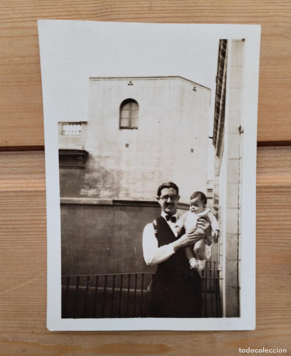 Fotografia antiga: Fotograf&iacute;a antigua de un hombre en traje y pajarita con un beb&eacute; en brazos