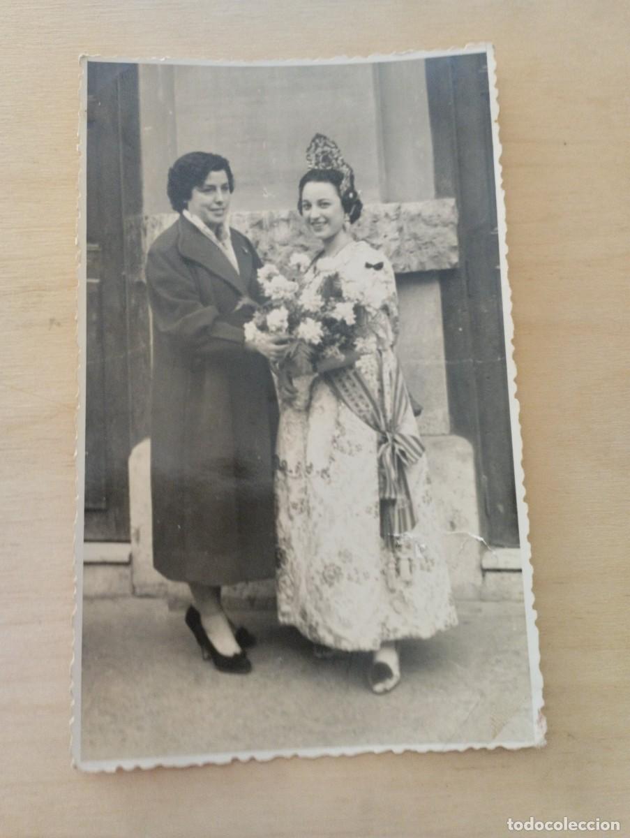 Fotograf&iacute;a antigua: Fotograf&iacute;a de fallera recibiendo flores en la calle. D&iacute;a de la Presentaci&oacute;n. Fallas, 1957.