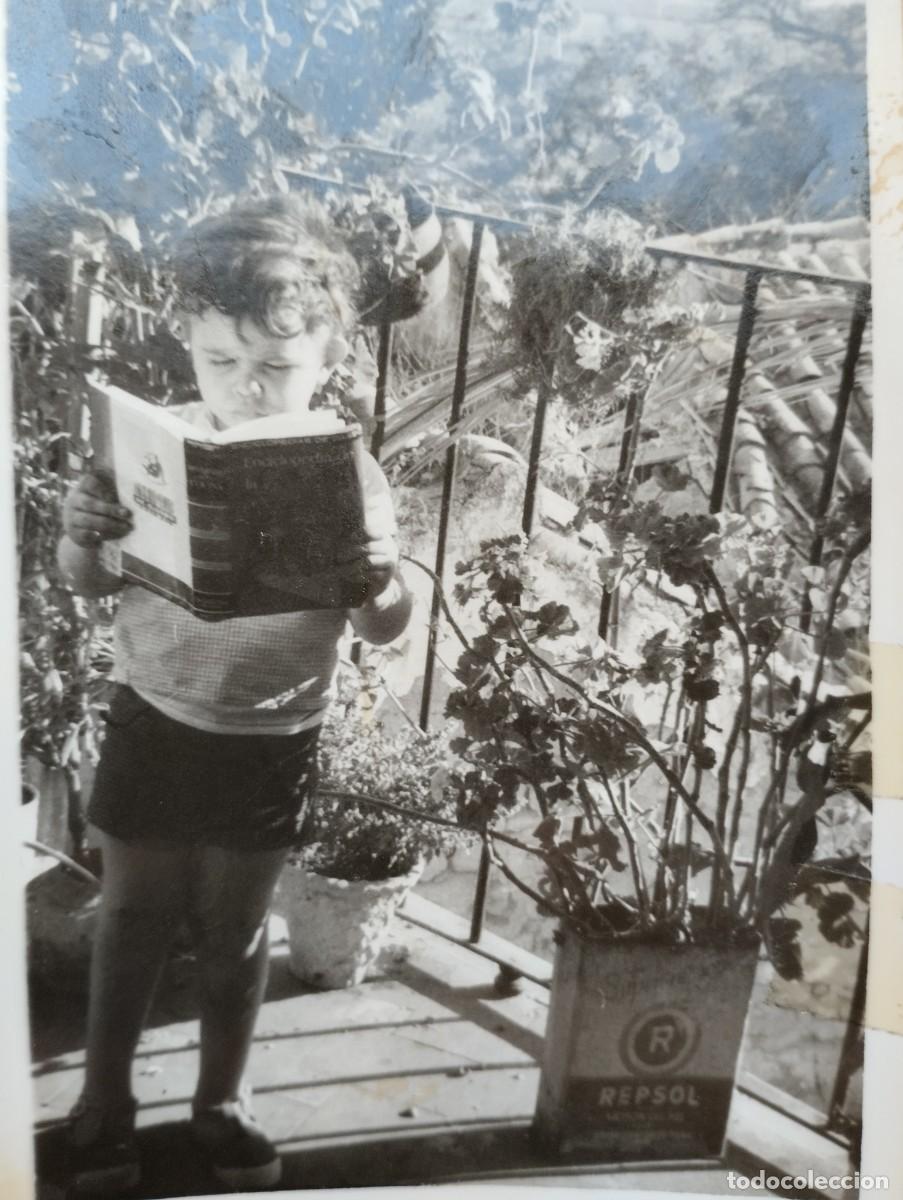 Fotografia antica: Fotograf&iacute;a antigua de un ni&ntilde;o leyendo junto a maceta de lata de Repsol