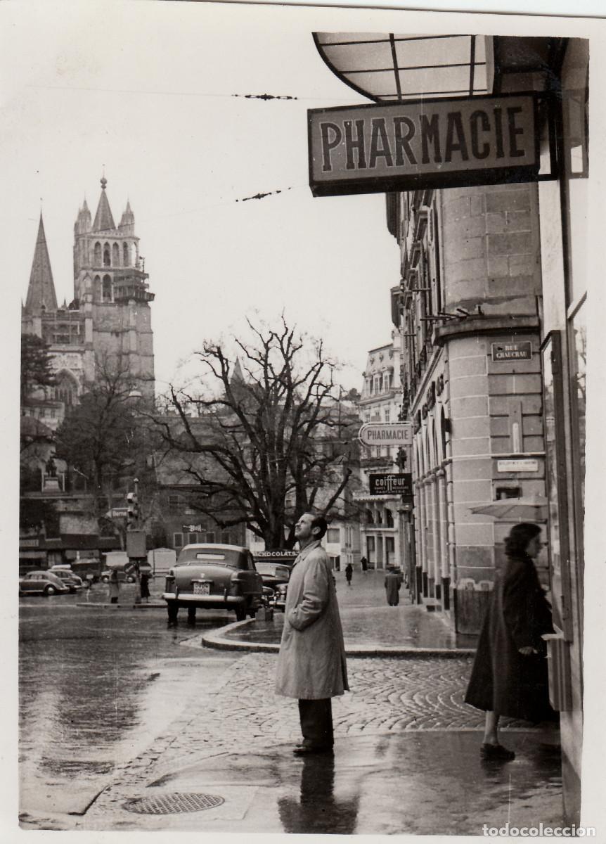 Fotograf&iacute;a antigua: Preciosa calle con coches antiguos en en d&iacute;a lluvioso. Al fondo catedral de Lausana Suiza 50s if