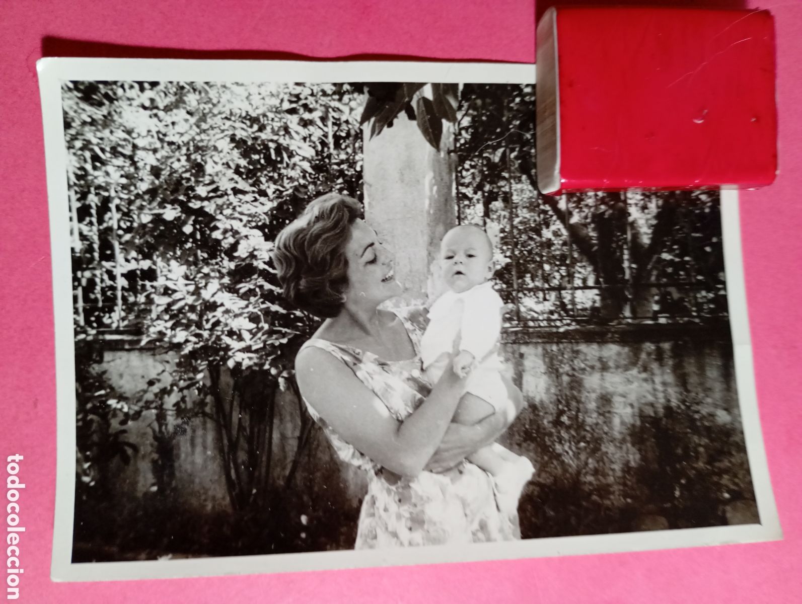 Fotograf&iacute;a antigua: mujer vestido estival floreado con un beb&eacute; pel&oacute;n y gordito muy serio en brazos b/n 50&acute;s ca.