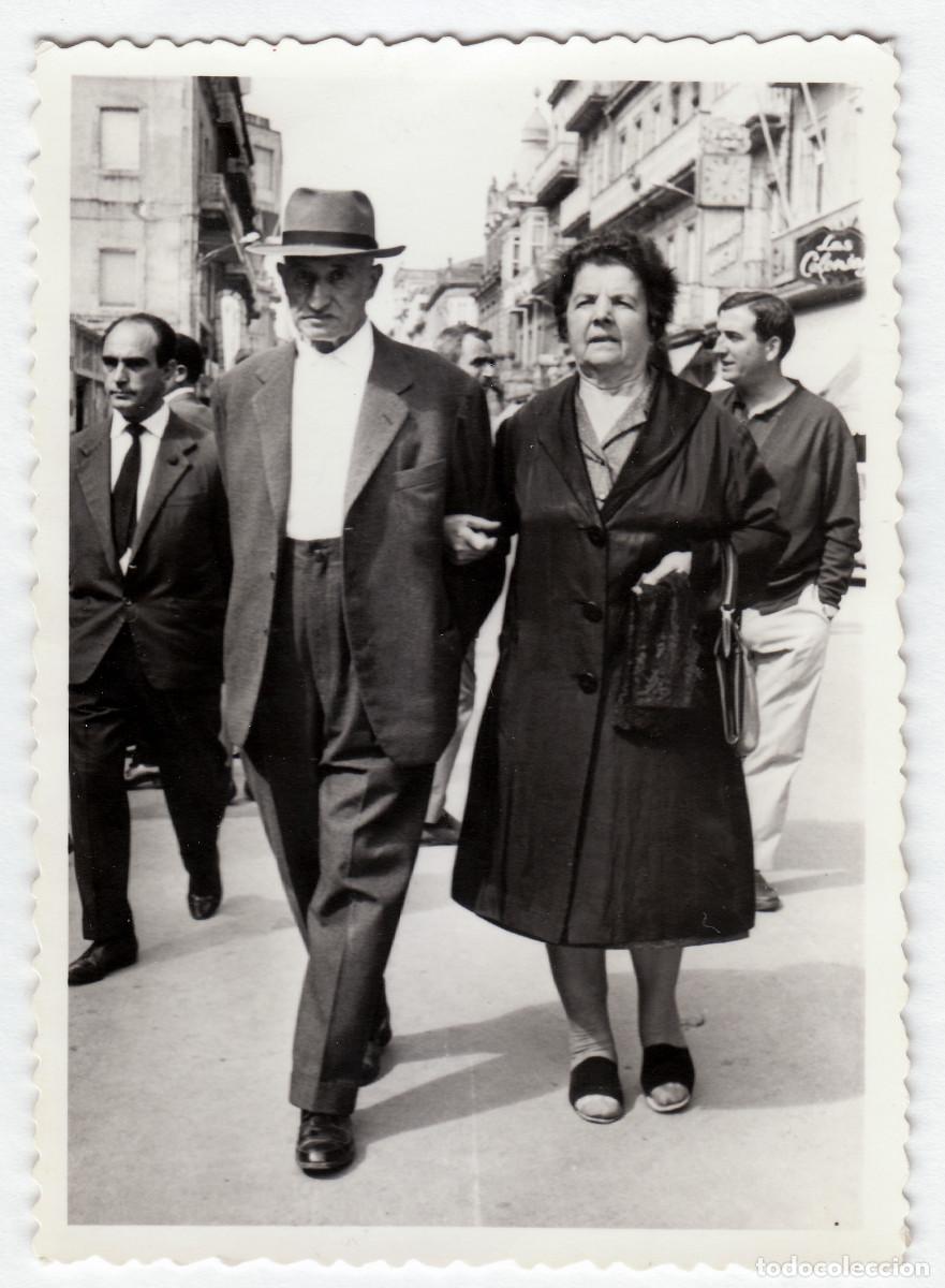 Fotograf&iacute;a antigua: Pareja paseando por una calle. Relojer&iacute;a. Las Colonias? Fot&oacute;grafo Vigo. A&ntilde;os 50 pc