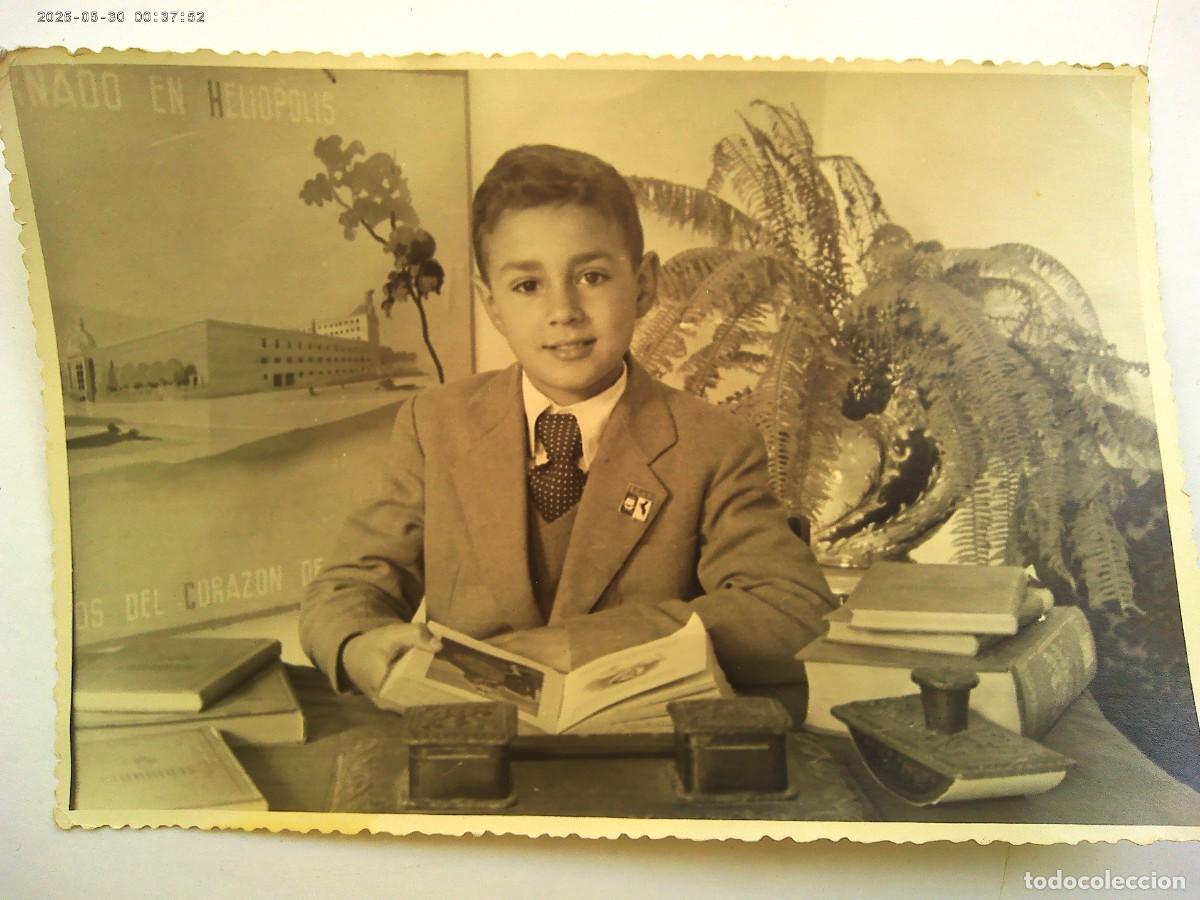 Fotograf&iacute;a antigua: FOTO ESCOLAR: NI&Ntilde;O ELEGANTE CON LIBRO. DETRAS CARTEL CORAZON DE JESUS, HELIOPOLIS ..... 11,5 X 17 CM