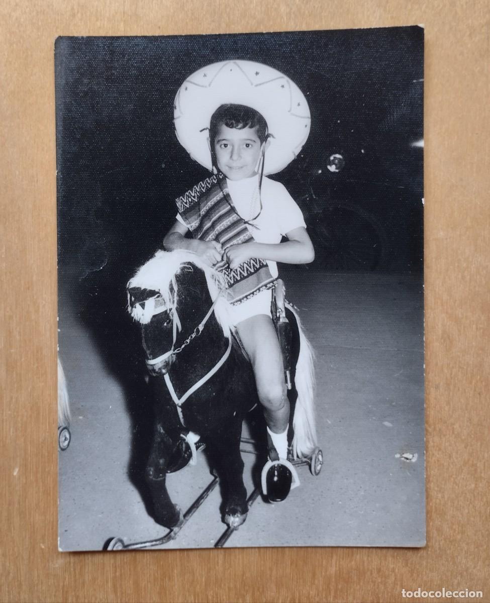 Photographie ancienne: Fotograf&iacute;a antigua de un ni&ntilde;o con sombrero y manta sobre caballos de juguete.
