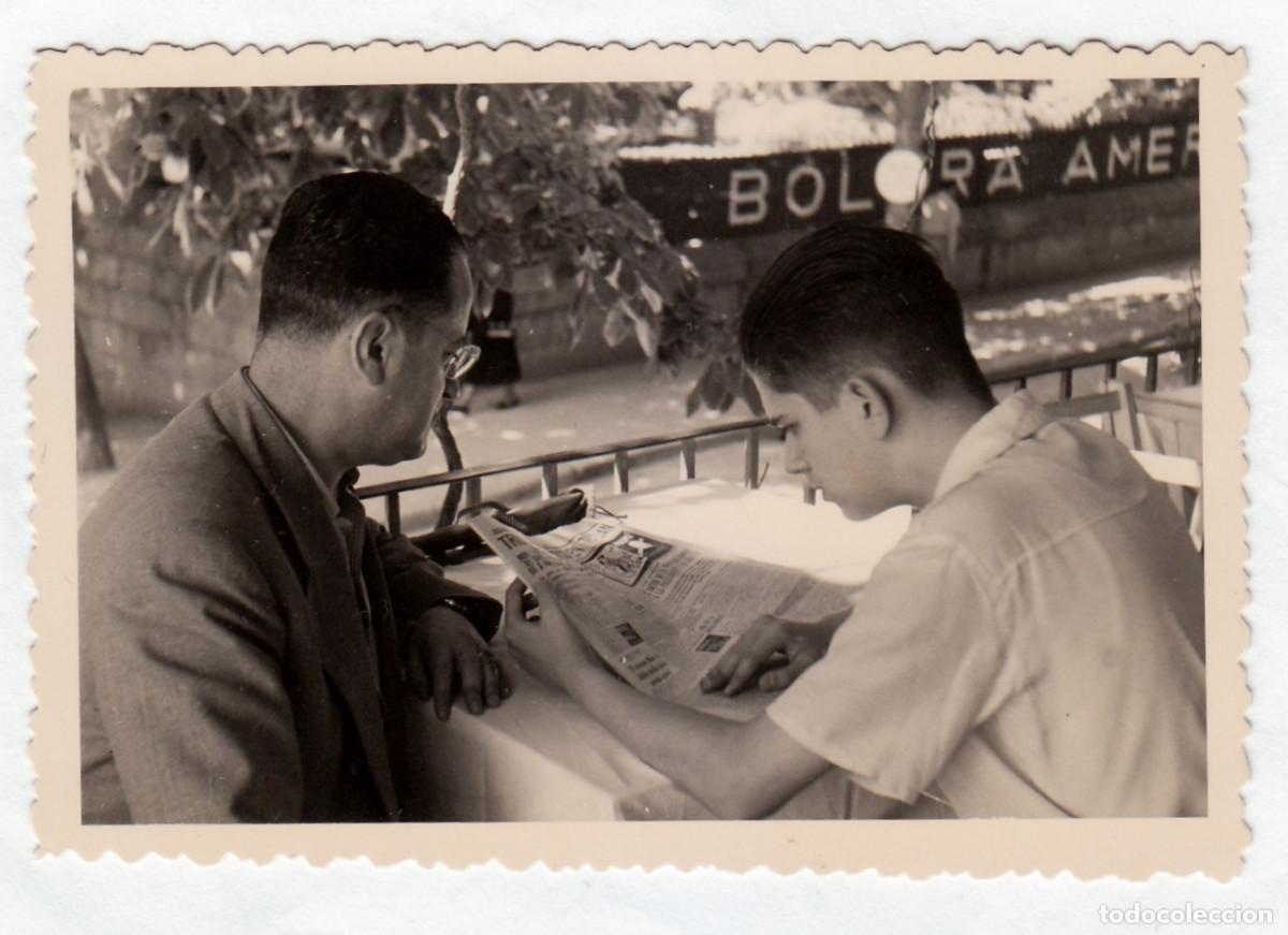 Fotograf&iacute;a antigua: Curiosa foto. Dos chicos leyendo el peri&oacute;dico. Al fondo Bolera Americana. A&ntilde;os 50 pc