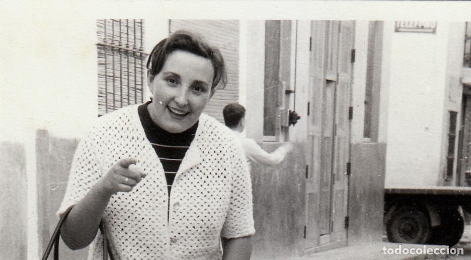 Fotograf&iacute;a antigua: Dama riendo. Al fondo antiguo cartel de tel&eacute;fonos. A&ntilde;os 60 pc