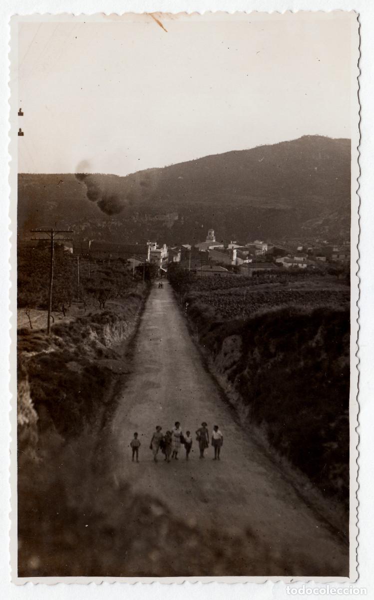 Fotograf&iacute;a antigua: Paseantes por la carretera. Preciosa vista de una poblaci&oacute;n entre monta&ntilde;as. Campanario. A&ntilde;os 60 pc