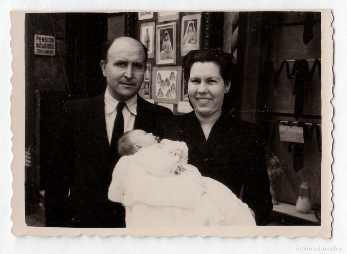 Fotograf&iacute;a antigua: Cartel de Pensi&oacute;n Navarro. Pareja con beb&eacute; delante de un estudio fotogr&aacute;fico. A&ntilde;os 40 pc