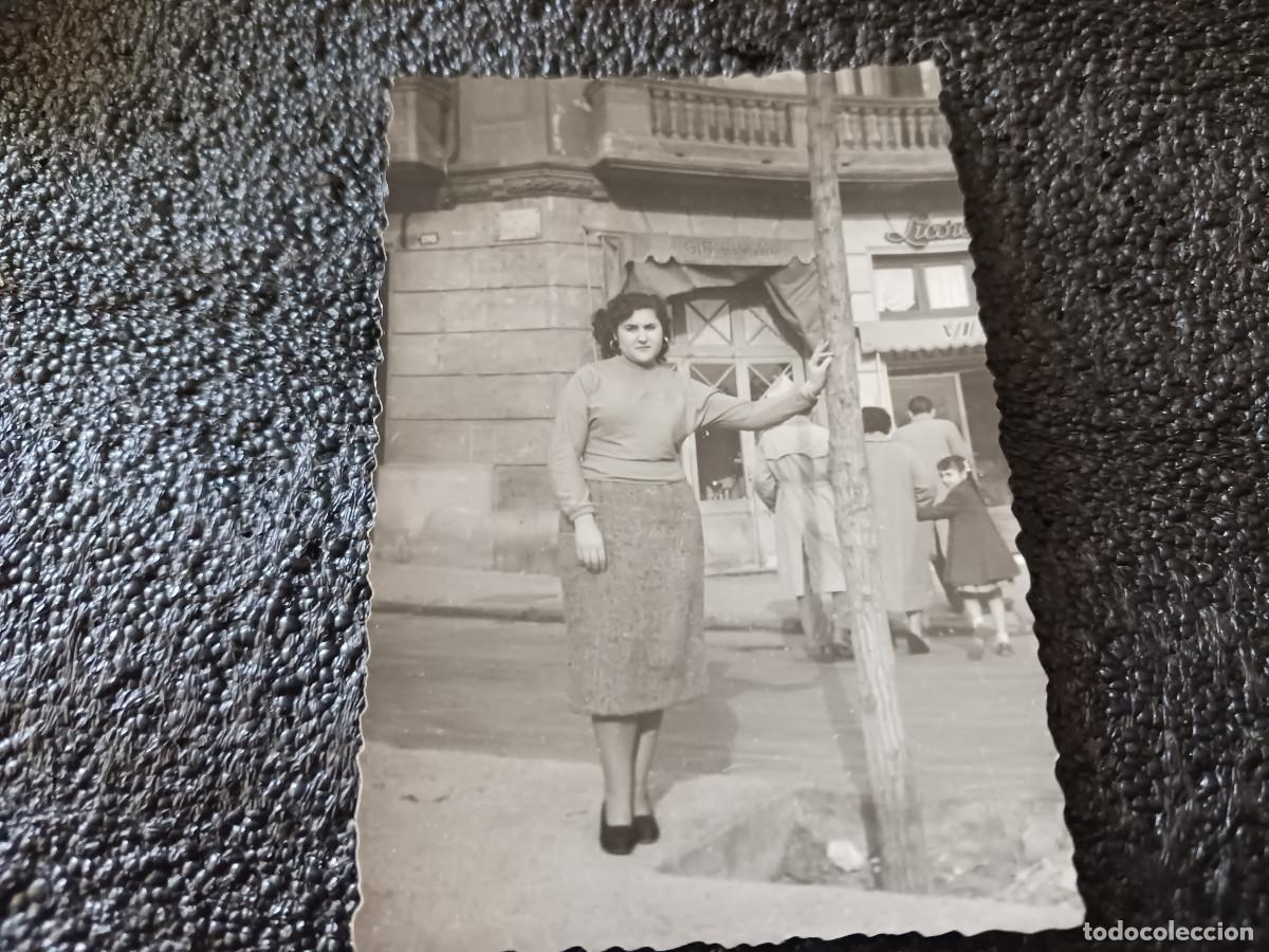 Fotograf&iacute;a antigua: antigua fotografia chica apoyada a un arbol frente a una licoreria, calle carlos 1&ordm; a&ntilde;o 1955