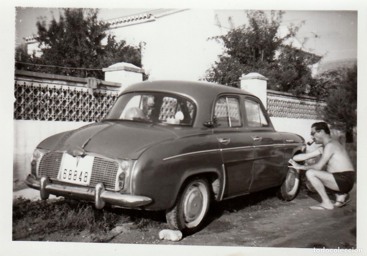Fotograf&iacute;a antigua: Caballero intentando cambiar una rueda de su Renault Dauphine Coche antiguo 60s sv