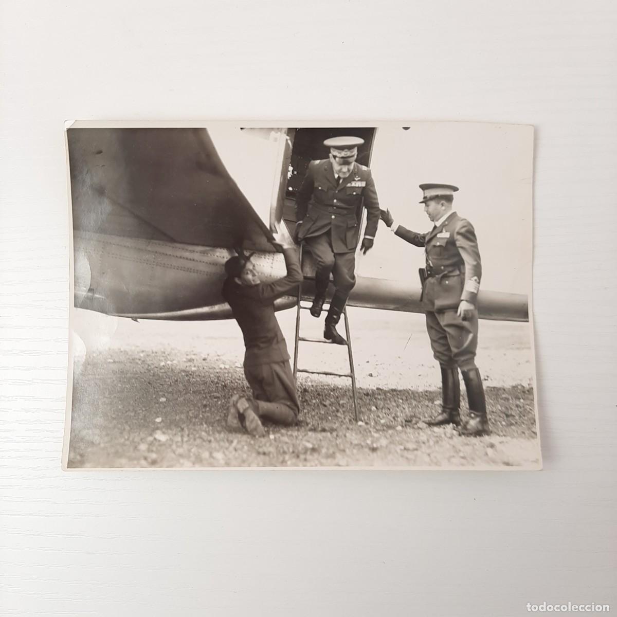 Fotografia antiga: Foto in b/n raffigurante un alto ufficiale dell'Aeronautica che scende dalla scaletta di un velivolo