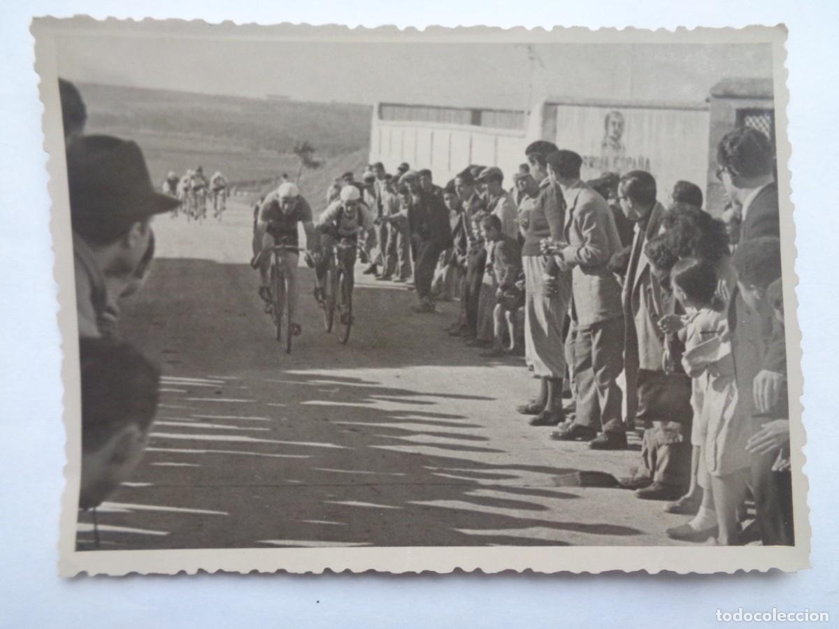 Fotograf&iacute;a antigua: CICLISMO: CICLISTAS PASANDO POR LOCALIDAD, PARED RETRATO DE FRANCO ARRIBA ESPA&Ntilde;A. DE NARBONA, SEVILL
