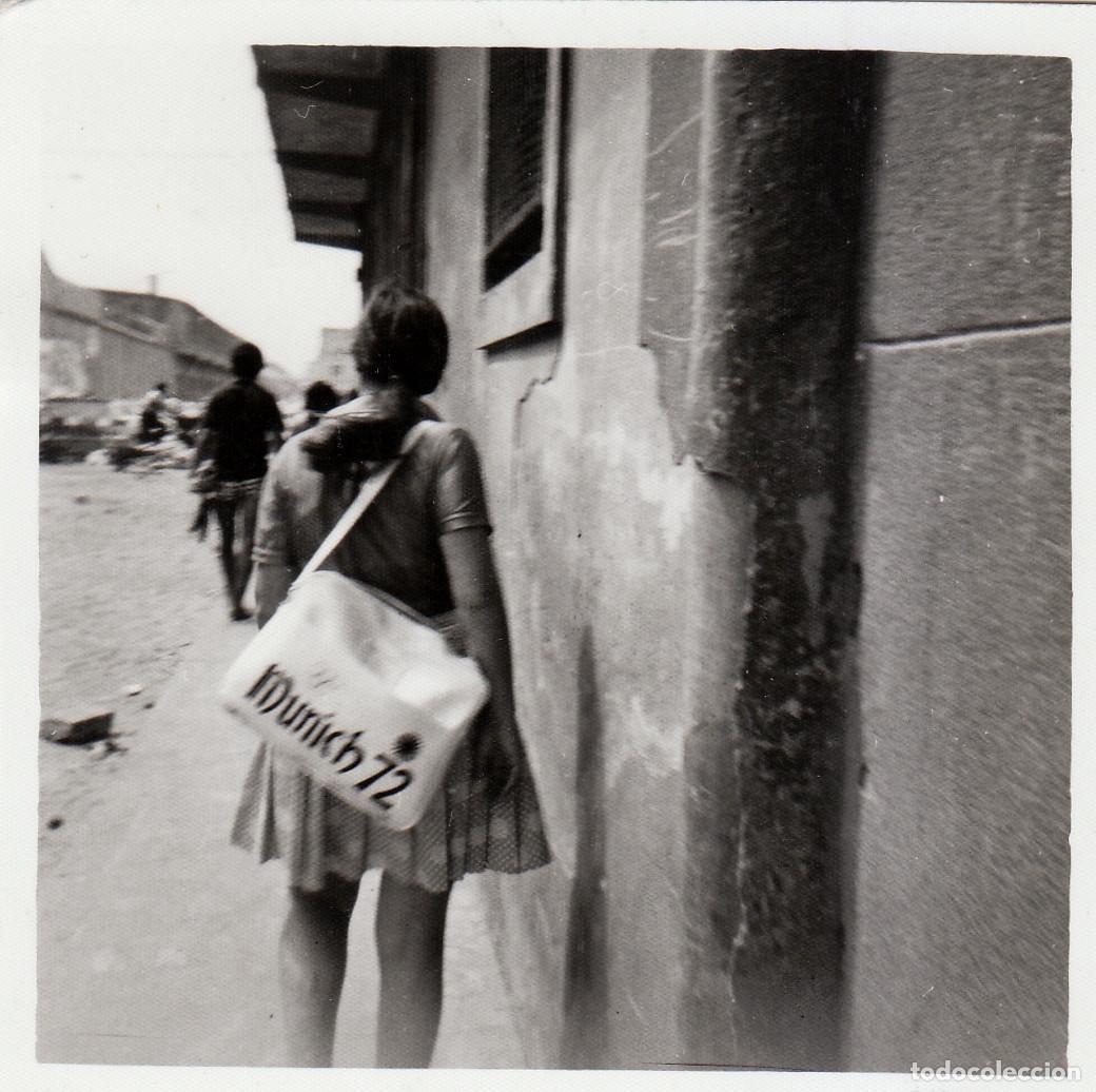 Fotograf&iacute;a antigua: Chica de espaldas con una cl&aacute;sica bolsa de Munich 72. A&ntilde;os 70 vf