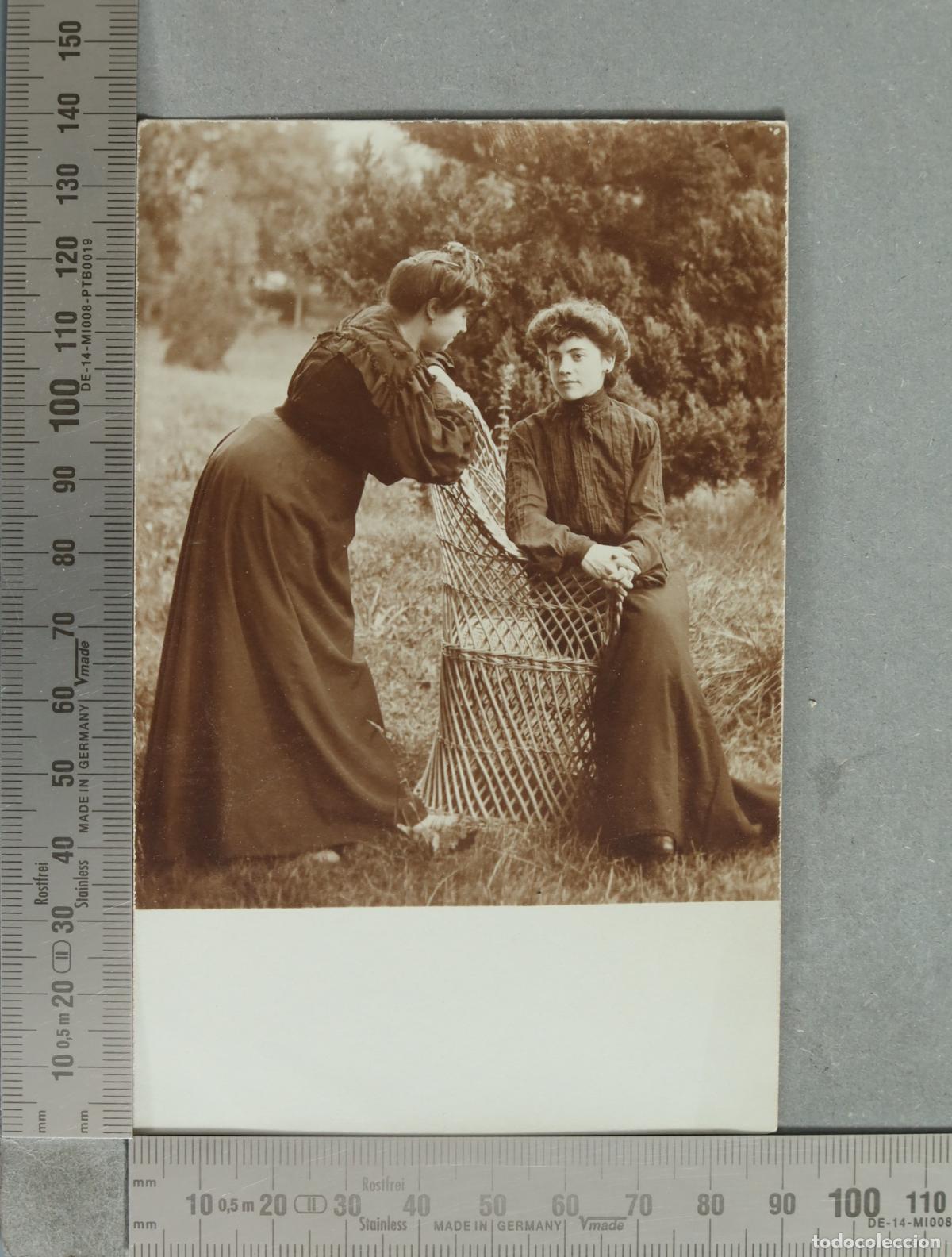 Fotograf&iacute;a antigua: FOTOGRAFIA PSOTAL. Dos mujeres junto a una silla de mimbre HACIA 1900