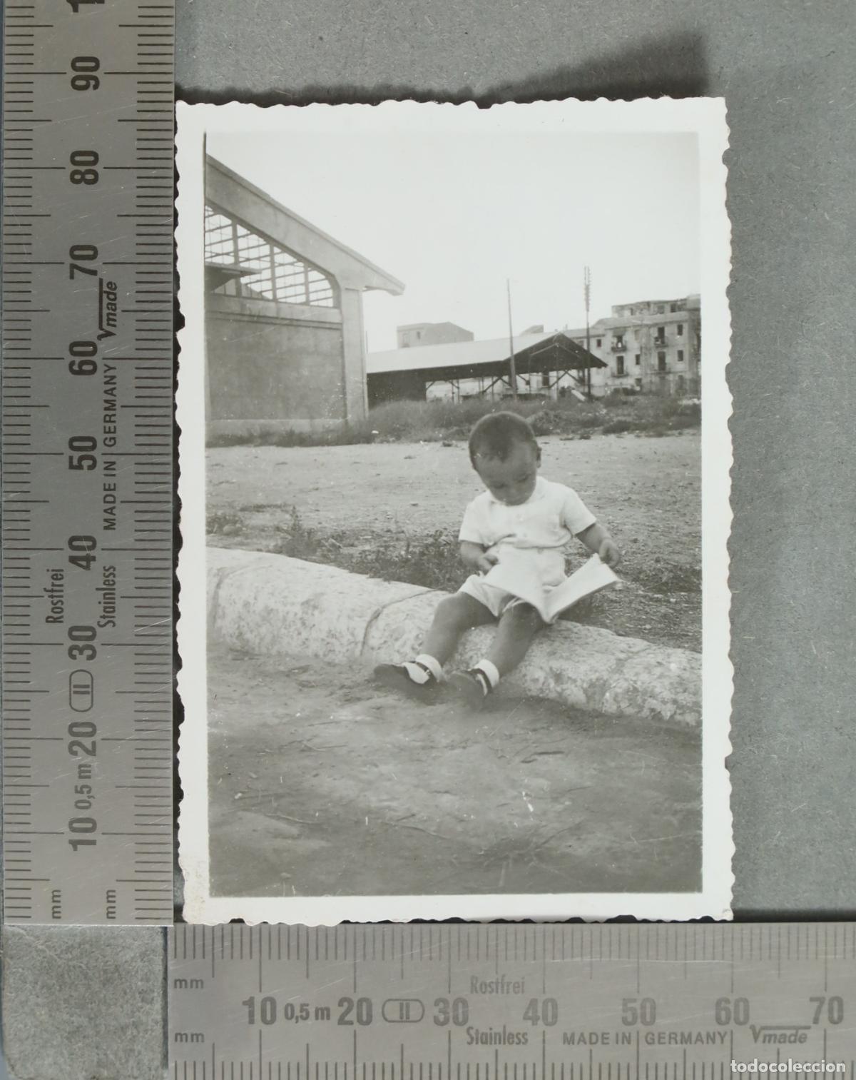 Fotografia antiga: FOTOGRAFIA. Ni&ntilde;o leyendo sentado en un bordillo hacia 1940