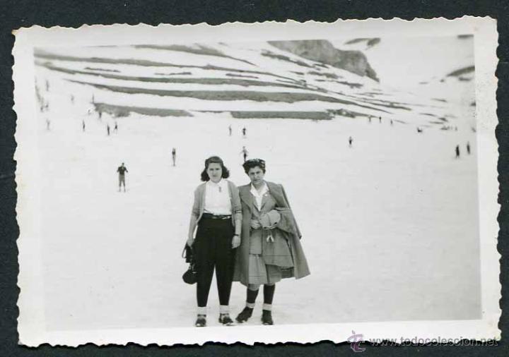 Fotograf&iacute;a antigua: N&uacute;ria. Dos se&ntilde;oras justo en medio de la pista de esqu&iacute;, con esquiadores al fondo. 1944