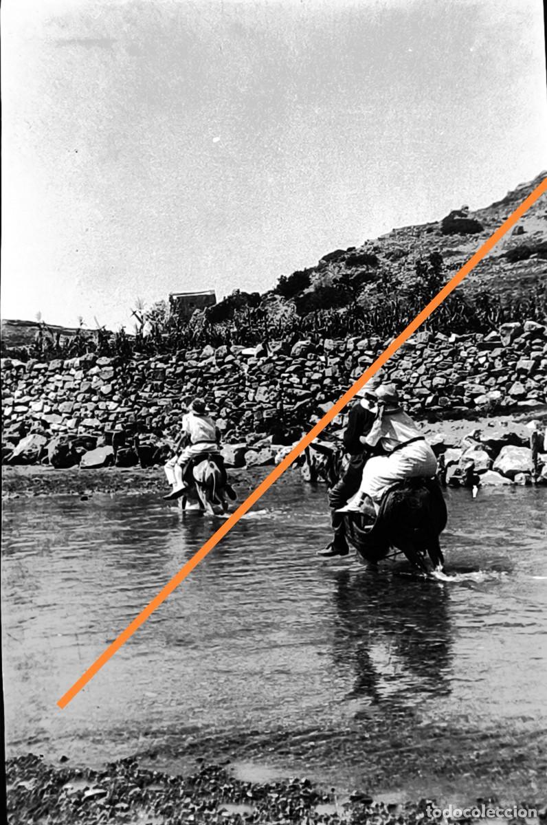 Fotograf&iacute;a antigua: Antiguo negativo de fotograf&iacute;a. Cruzando el r&iacute;o en el borrico. A&ntilde;os 20