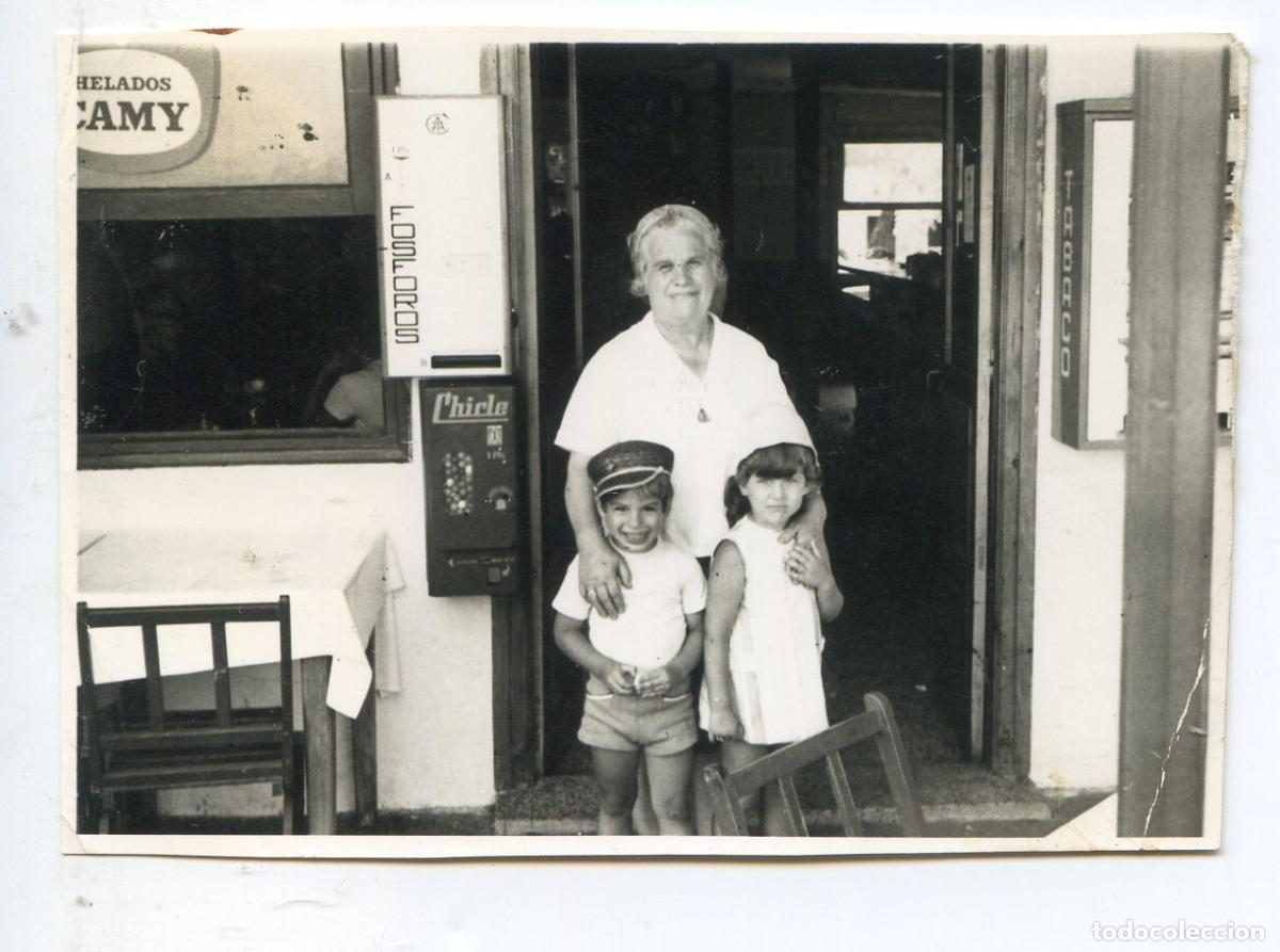 Antique Photography: Fotograf&iacute;a de se&ntilde;ora con dos ni&ntilde;os a la entrada de un bar con m&aacute;quinas de chicle, f&oacute;sforos y tabaco