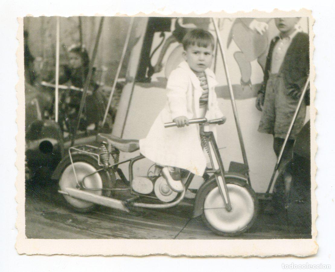 Fotograf&iacute;a antigua: Ni&ntilde;o en moto de carrusel de feria, a&ntilde;os 60