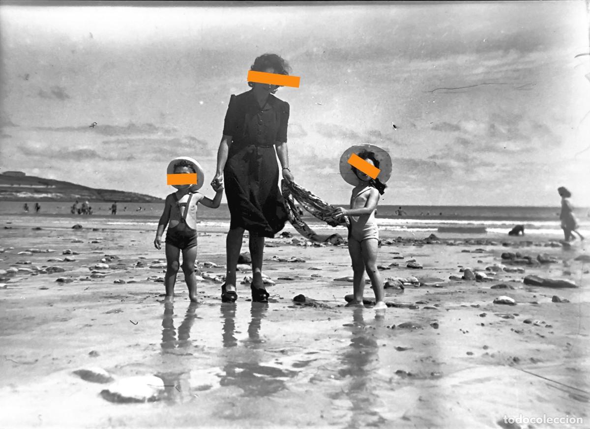 Fotograf&iacute;a antigua: Antiguo negativo de fotograf&iacute;a. Chica y ni&ntilde;os en la orilla del mar. A&ntilde;os 40.