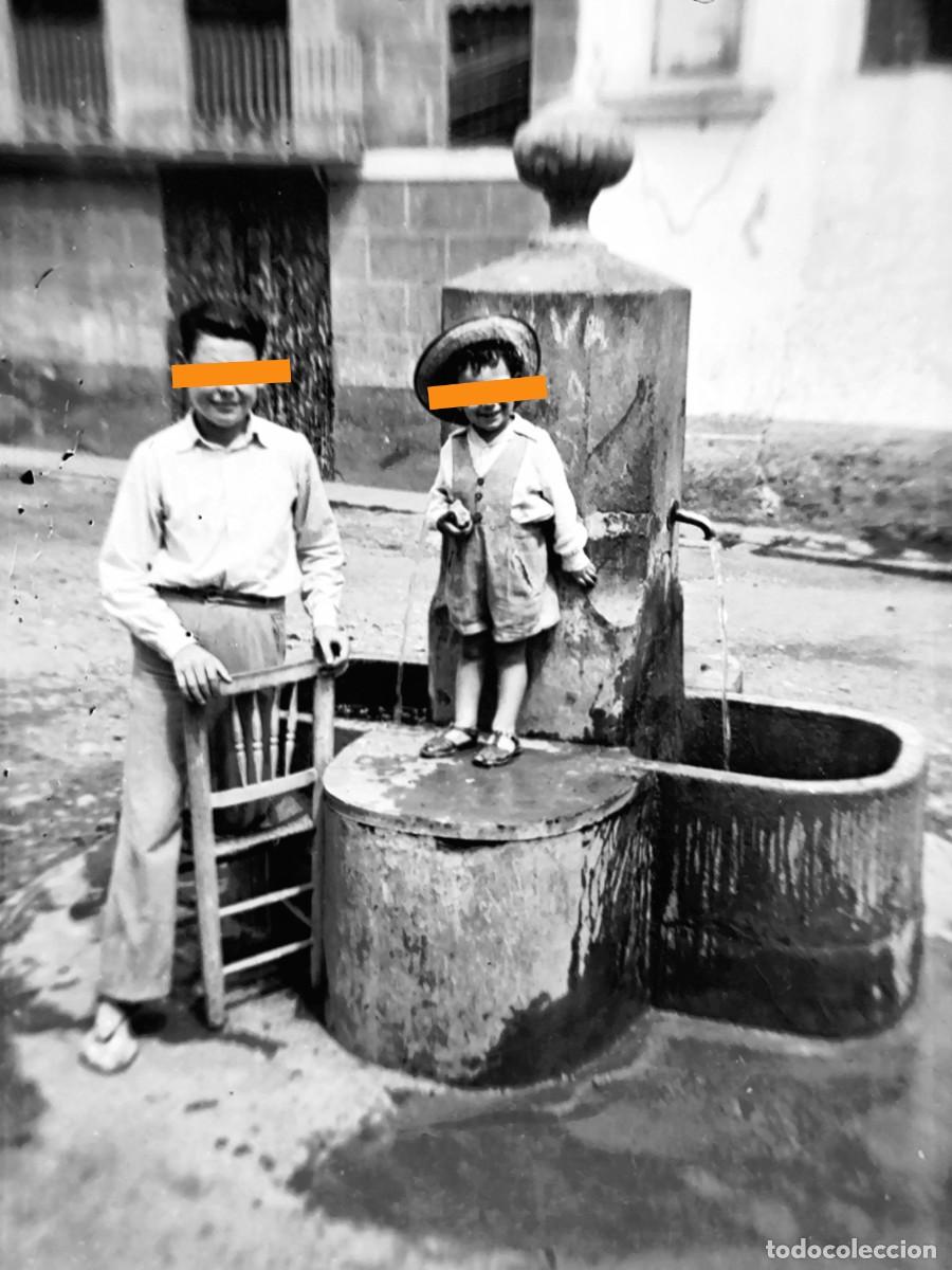 Fotograf&iacute;a antigua: Antiguo negativo de fotograf&iacute;a. Chico y ni&ntilde;a junto a la fuente. A&ntilde;os 20/30