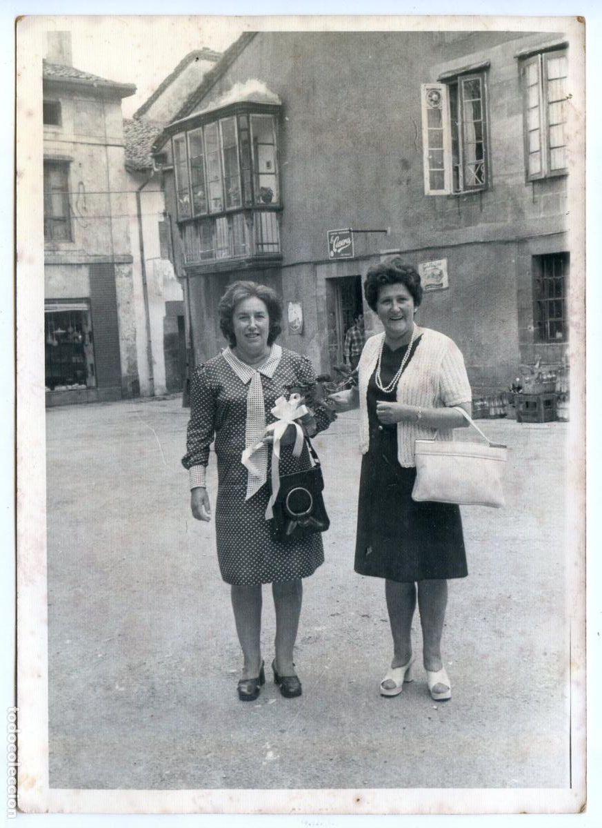 Fotograf&iacute;a antigua: Dos se&ntilde;oras en la plaza de un pueblo a identificar con tienda detr&aacute;s, Cantabria, a&ntilde;os 70