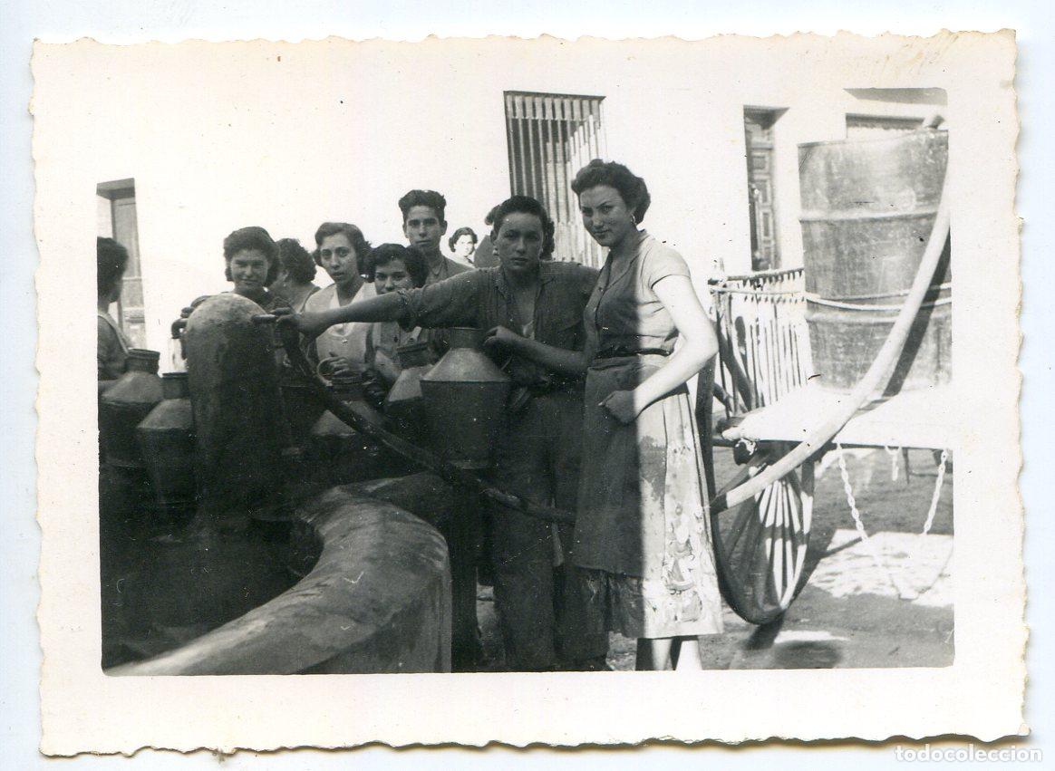 Fotograf&iacute;a antigua: Se&ntilde;oras en la fuente del pueblo y carro con bid&oacute;n de agua. Lugar a identificar, a&ntilde;os 50