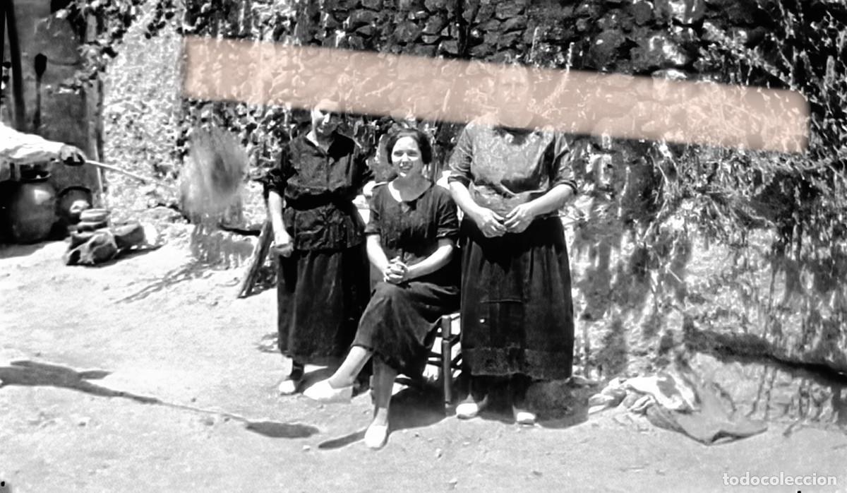 Fotograf&iacute;a antigua: Antiguo negativo de fotograf&iacute;a. Tres mujeres junto a una casa de piedra. A&ntilde;os 30
