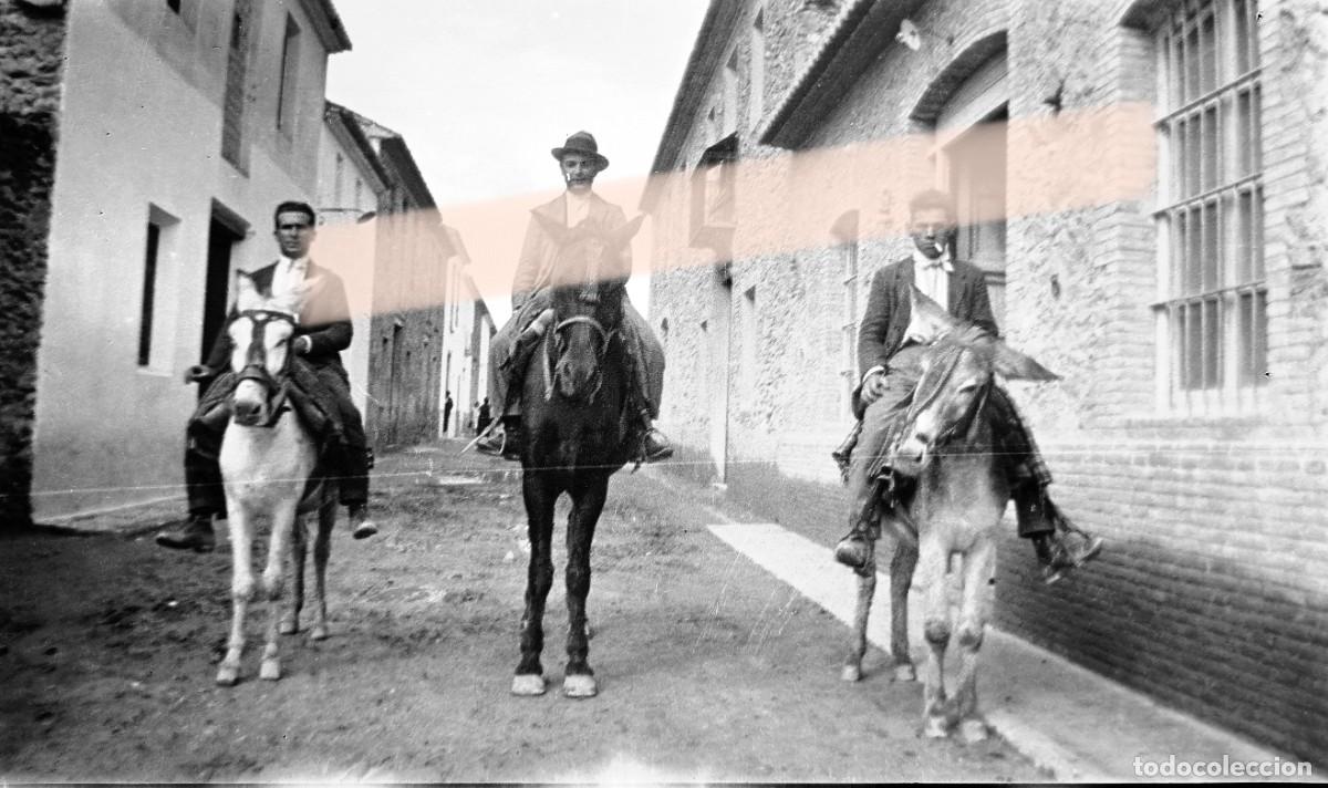 Fotograf&iacute;a antigua: Antiguo negativo de fotograf&iacute;a. Tres hombres a caballo por una calle del pueblo. A&ntilde;os 30