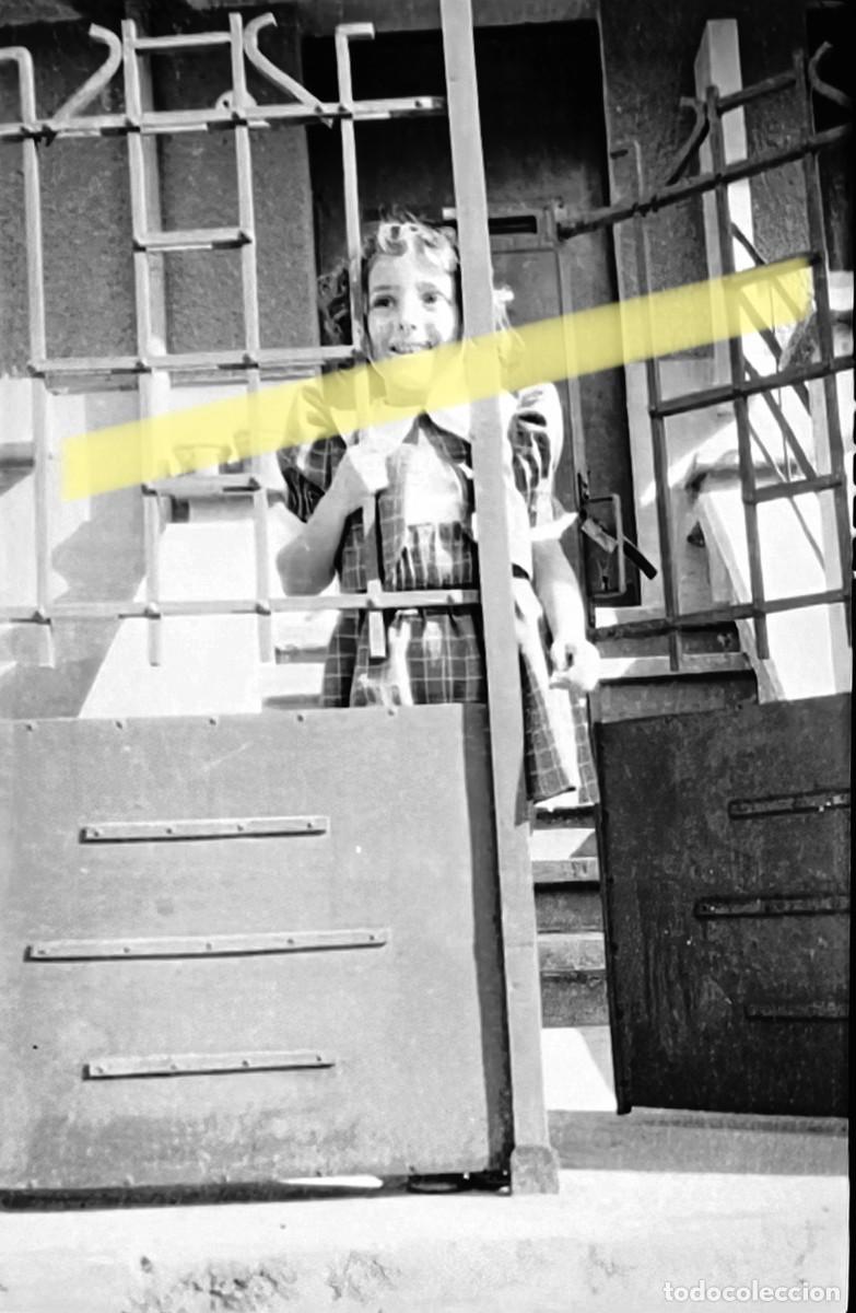 Fotograf&iacute;a antigua: Antiguo negativo de fotograf&iacute;a. Ni&ntilde;a asomada tras una reja. A&ntilde;os 40