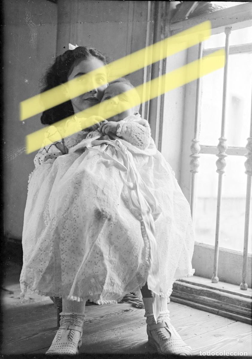 Fotograf&iacute;a antigua: Antiguo negativo de fotograf&iacute;a. Ni&ntilde;a sosteniendo a un beb&eacute;. A&ntilde;os 40