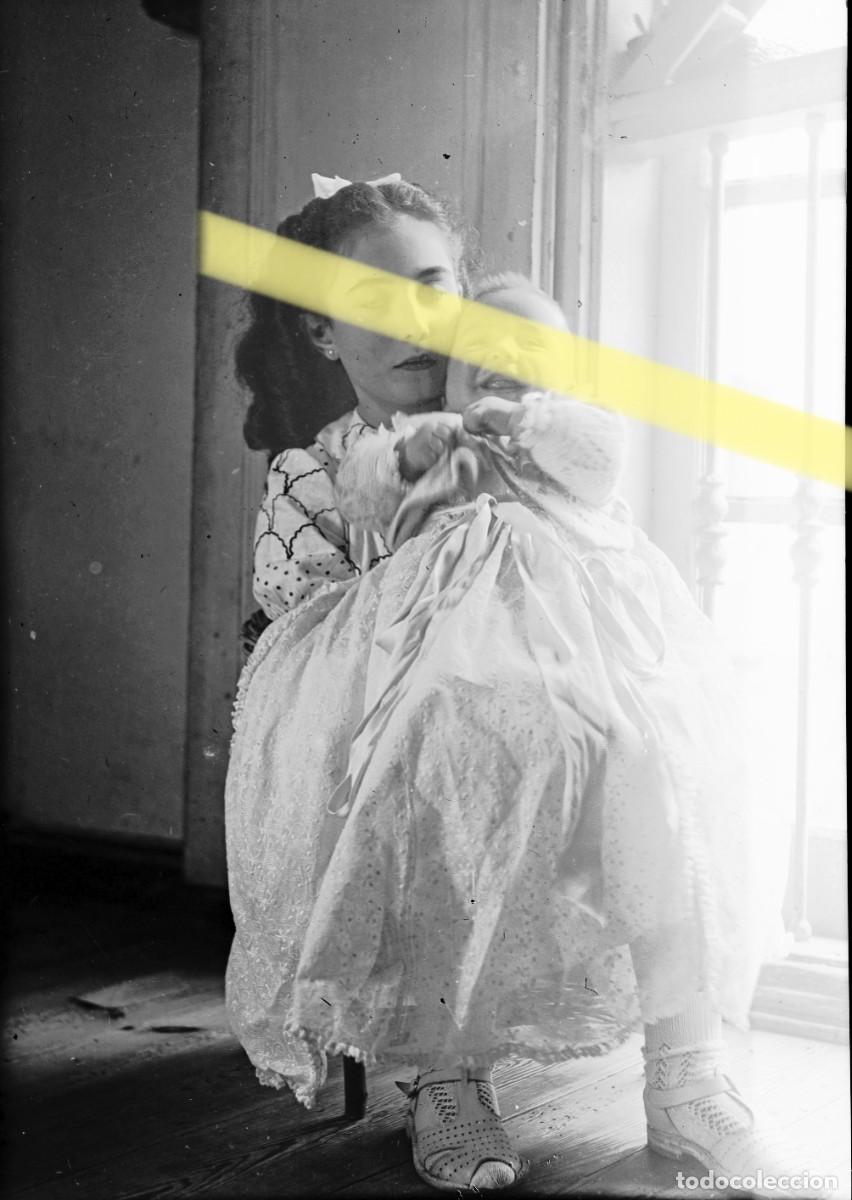 Fotograf&iacute;a antigua: Antiguo negativo de fotograf&iacute;a. Ni&ntilde;a sosteniendo a un beb&eacute;. A&ntilde;os 40
