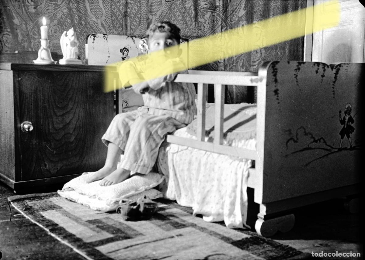Fotograf&iacute;a antigua: Antiguo negativo de fotograf&iacute;a. Ni&ntilde;o sentado junto a una cama. A&ntilde;os 40