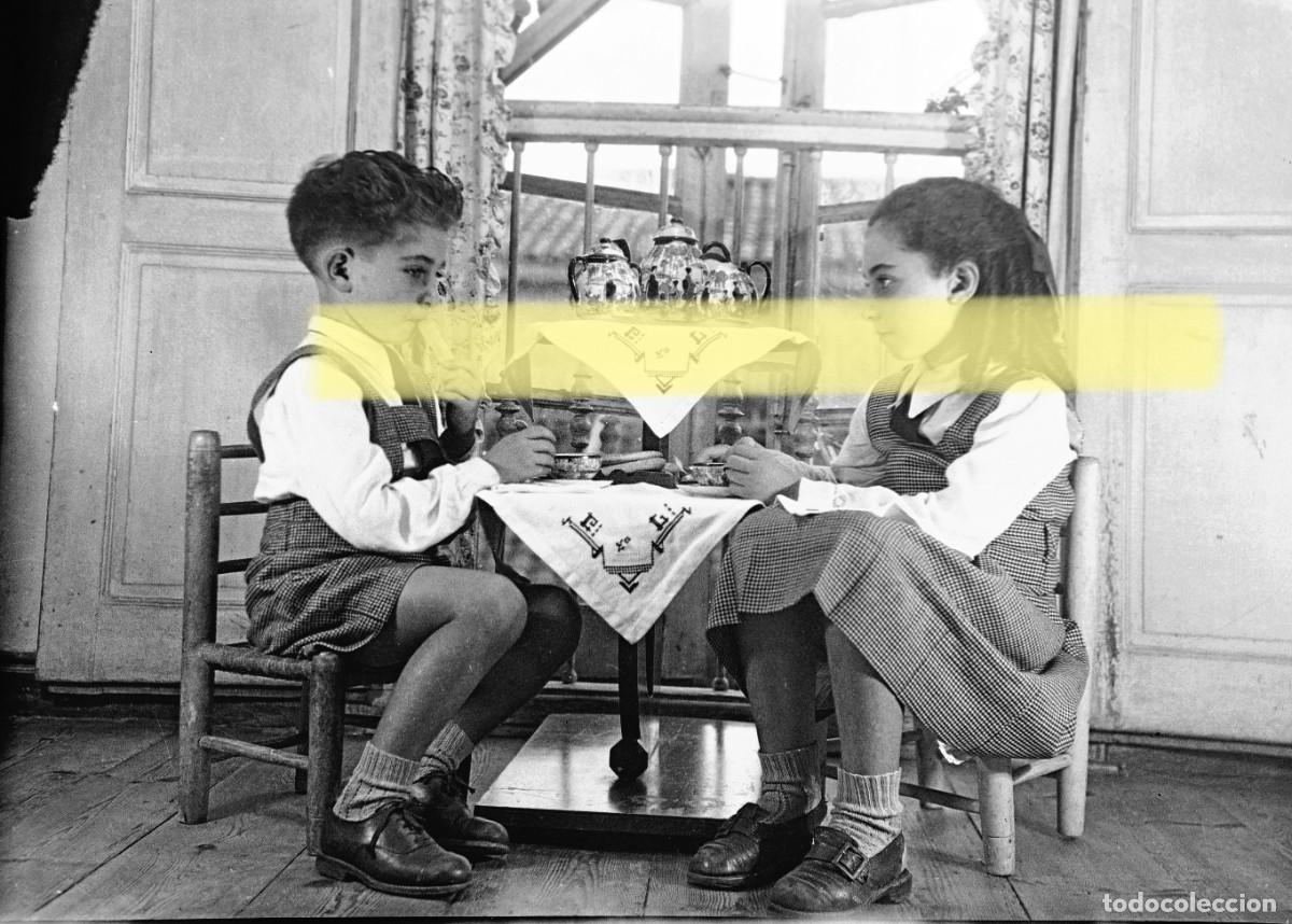 Fotograf&iacute;a antigua: Antiguo negativo de fotograf&iacute;a. Ni&ntilde;o y ni&ntilde;a tomando el t&eacute;. A&ntilde;os 40
