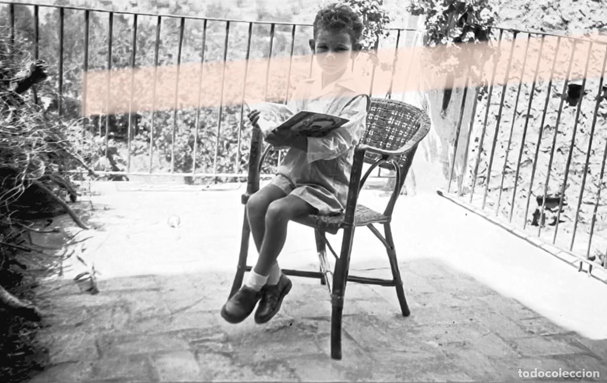 Fotograf&iacute;a antigua: Antiguo negativo de fotograf&iacute;a. Ni&ntilde;o leyendo en una terraza. A&ntilde;os 30/40