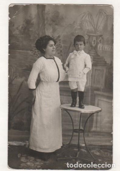 Fotografia antiga: Postal fotogr&aacute;fica retrato madre con hijo subido a una mesa. Curioso tel&oacute;n. No figura fot&oacute;grafo.