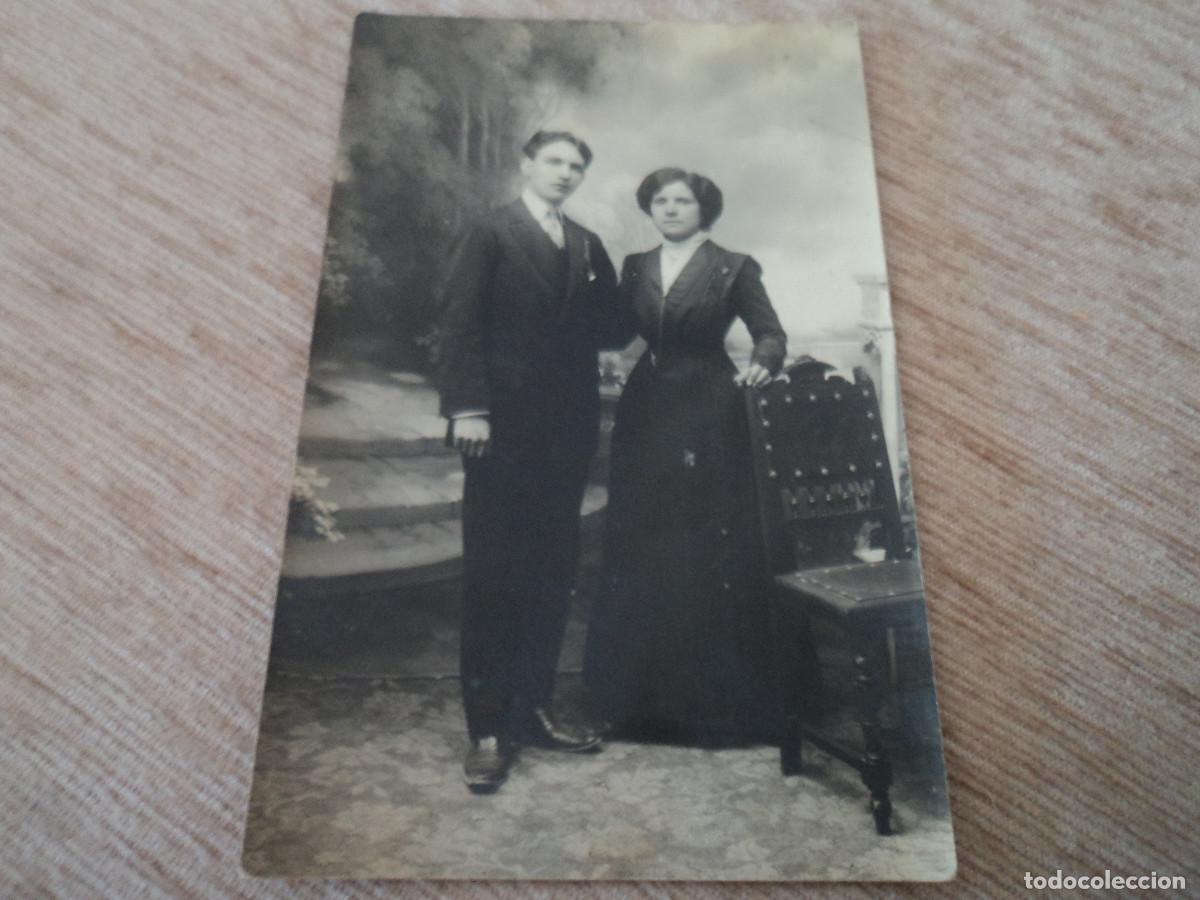 Fotografia antica: tarjeta postal pareja posando en mural