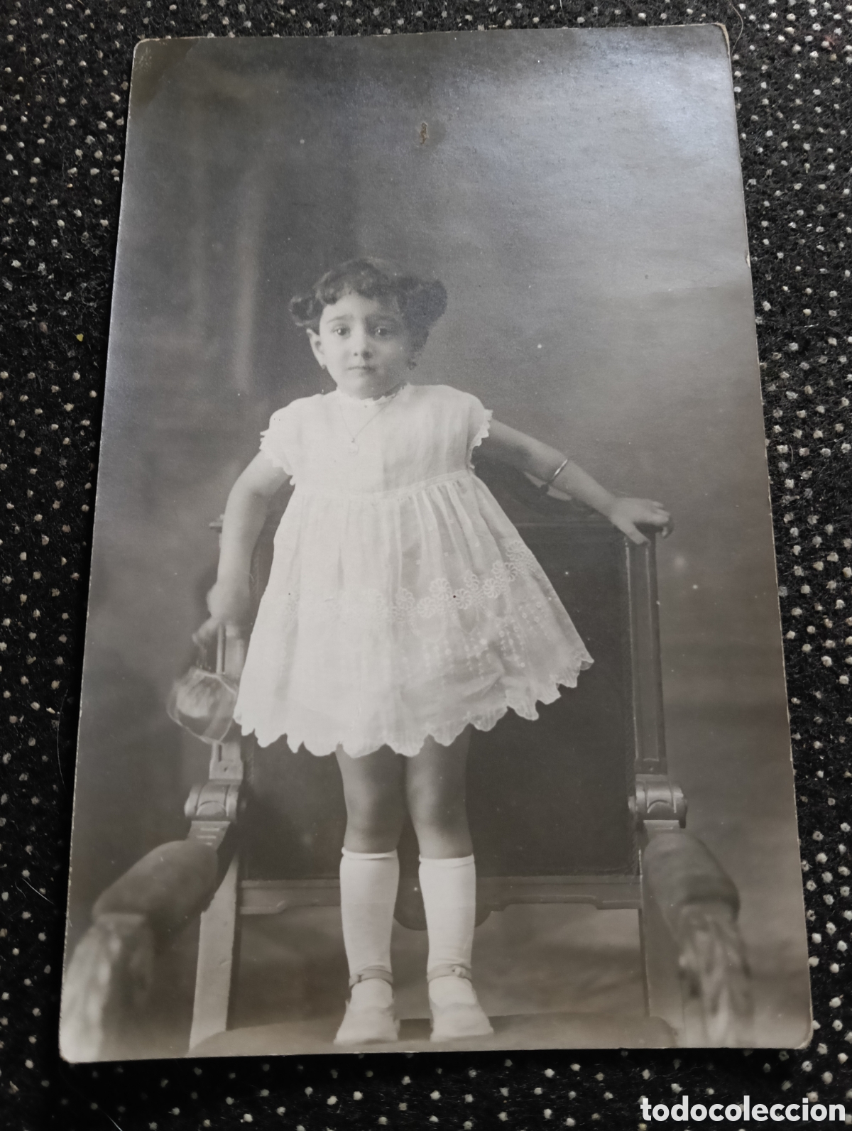 Alte Fotografie: Fotograf&iacute;a tama&ntilde;o postal de una ni&ntilde;a encima de un sill&oacute;n de los a&ntilde;os 30