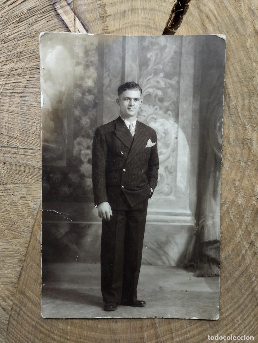 Photographie ancienne: Fotograf&iacute;a antigua de estudio de un joven hombre vestido con traje posando de pie.