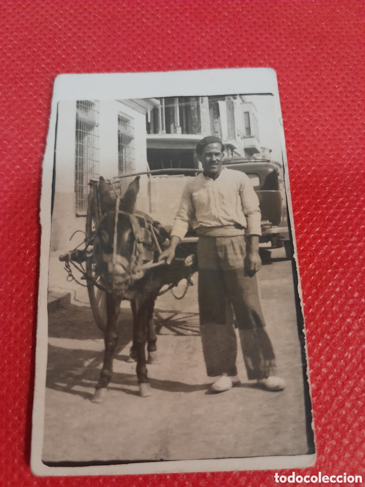 Fotograf&iacute;a antigua: Foto con hombre y un carro y burro al fondo se ve un coche